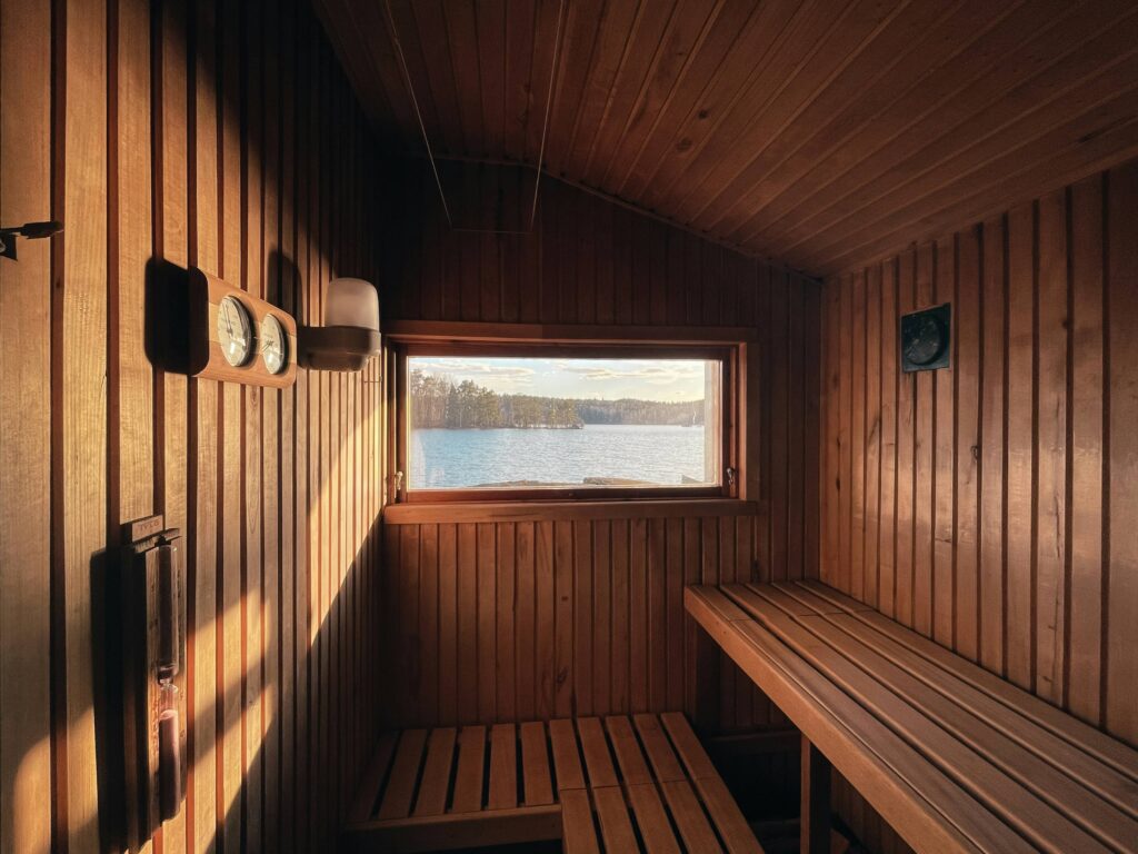 Wooden sauna interior with benches and a window letting in light